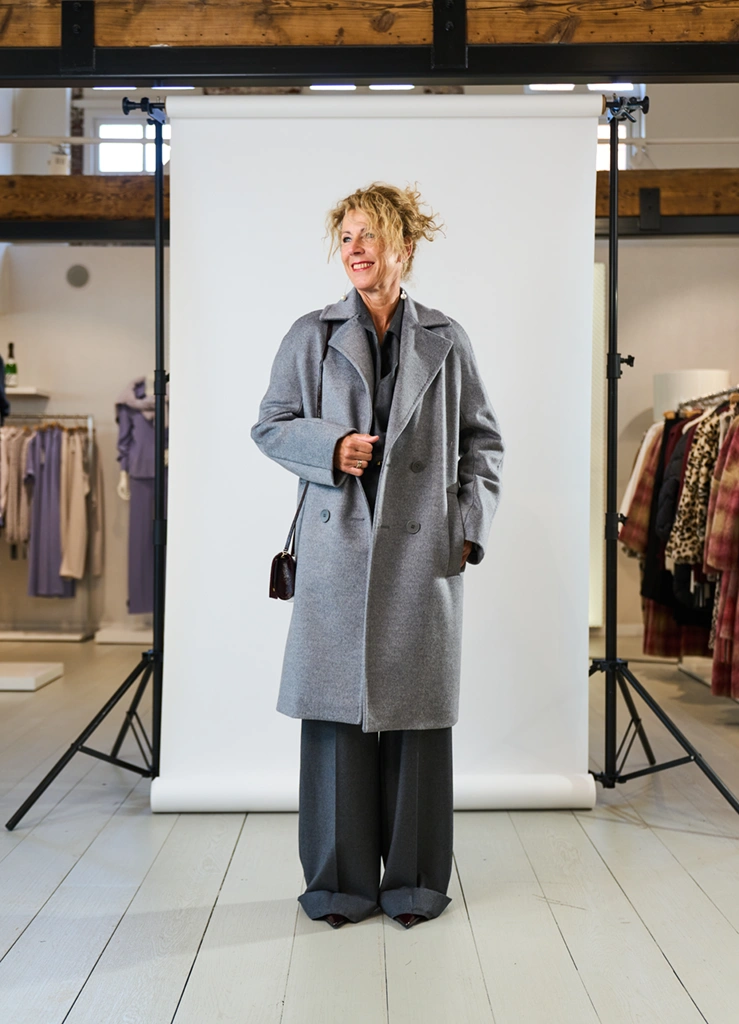 Vrouw in een trendy grijze mantel