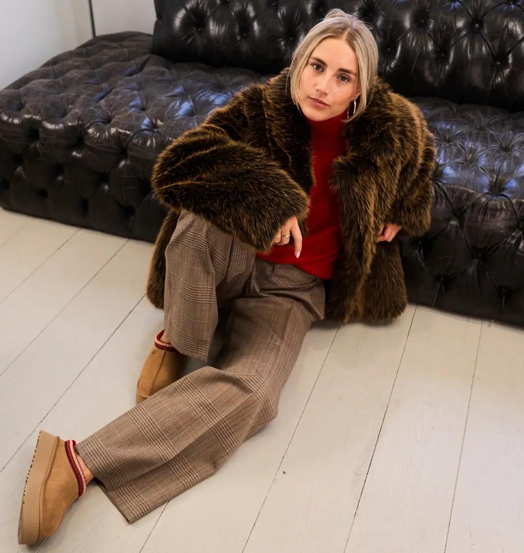 Vrouw draagt een imitatiebontjas, een fashion trend.