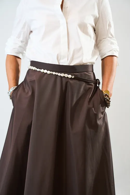 Fashion Trends 2025 9 Model in een wit shirt met lange mouwen en een bruine leren rok