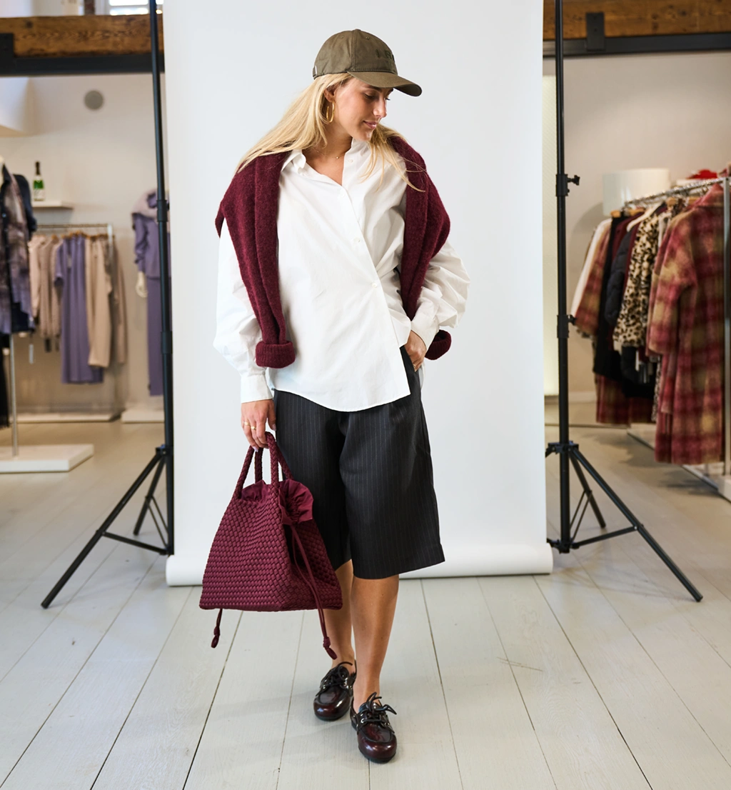 Een vrouw in een stijlvolle combinatie van de kleuren wit, zwart en bordeauxrood