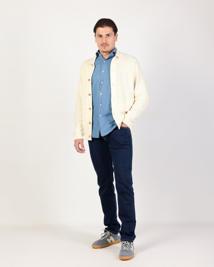 Casual heren outfit met crème vest, denim overhemd en donkerblauwe jeans