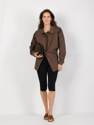 Bruine utility-jas met zwarte capribroek, bruine clutch en gevlochten sandalen